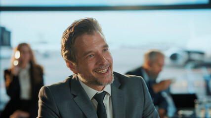 Smiling businessman relaxing in airport lounge before boarding