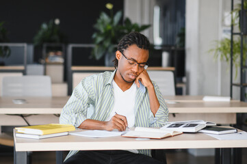 Focused university student studying hard in library
