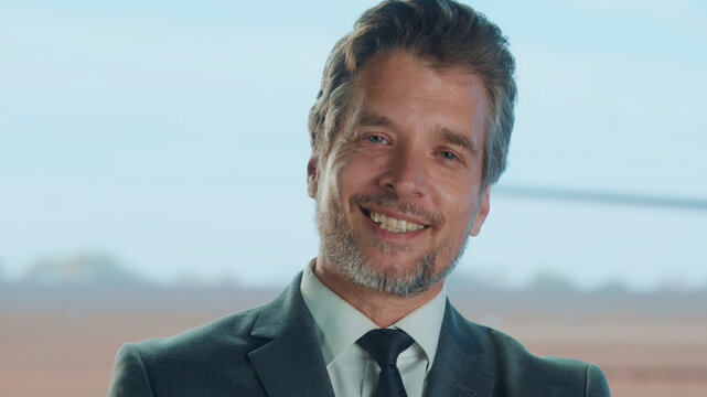 Smiling businessman waiting at airport lounge - Powered by Adobe