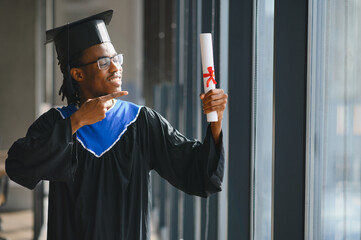 Proud graduate pointing at diploma celebrating university achievement
