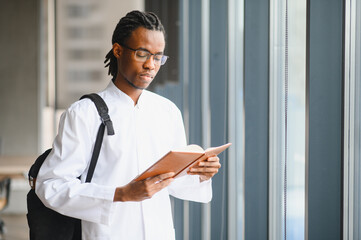 Young medical student reading a book in university hallway