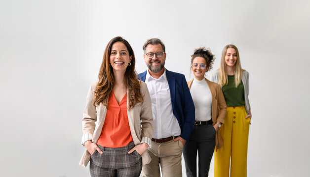 Portrait of successful professional leaders standing in a row and posing together on white background