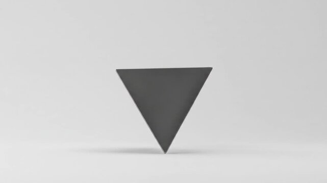 Black metal pyramid rotating on a light background  