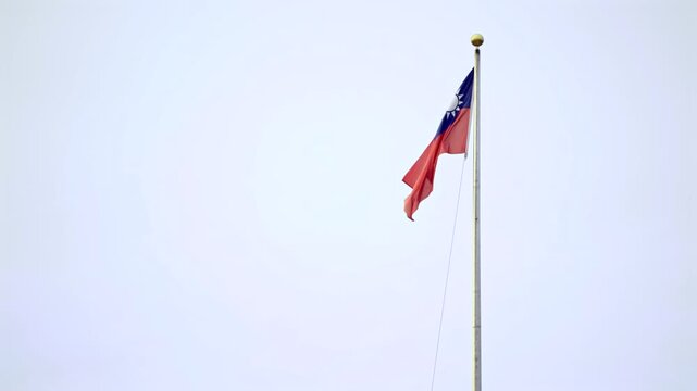 Slow motion of Taiwan flag waving high on a tall pole against the sky, symbolizing freedom and independence in Taiwan.