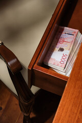 A stack of Russian rubles banknotes in the drawer of the desk. Five Thousand Rubles Banknotes In Stack in a wooden table.  Selective focus