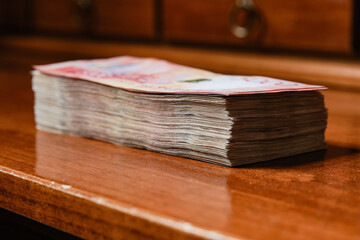  Banknotes In Stack on a wooden table. Selective focus