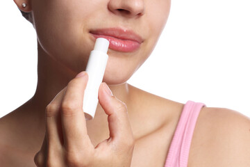 Young woman with lip balm on white background, closeup
