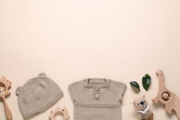 Baby clothes and accessories on beige background, flat lay. Space for text