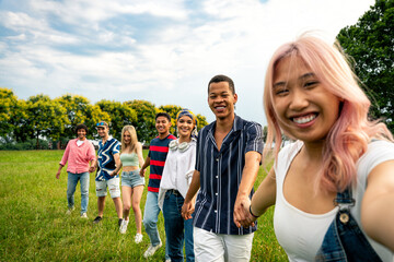Group of multiethnic teenagers spending time outdoor on a picnic at the park
