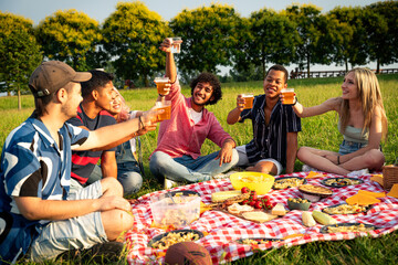 Group of multiethnic teenagers spending time outdoor on a picnic at the park