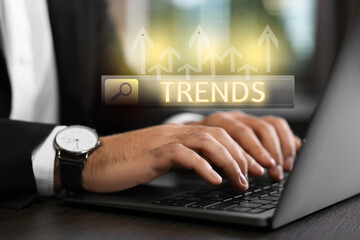 Businessman using laptop to find hot tendencies, new ideas, popular directions at table, closeup....
