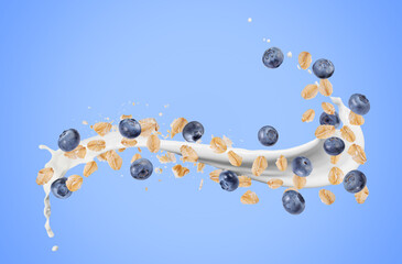 Oat flakes with fresh blueberries and milk splash flying on light blue background