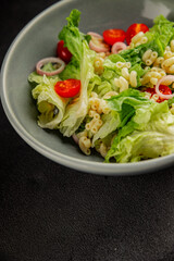 Pasta salad green leaf lettuce, tomato, pasta, onion fresh delicious gourmet food background on the table rustic food top view copy space keto and paleo diet vegan and vegetarian food