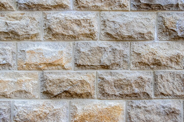 Solid block stone wall with distinctive texture and varied shades, creating a reliable and natural background