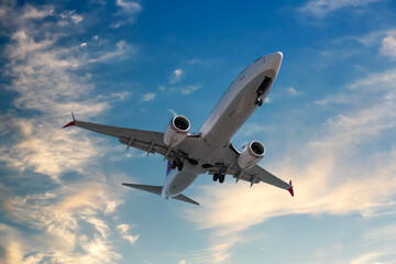 Airplane flying in beautiful blue sky with clouds