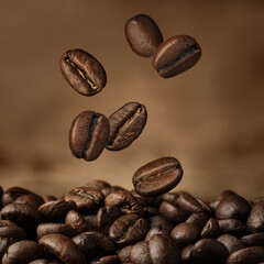 Roasted coffee beans falling against brown background, closeup