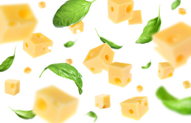 Cheese cubes and green basil leaves falling against white background