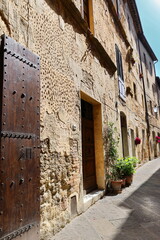 Chipped facades of Medieval townhouses lining the Corso il Rossellino Street north side, eastward from Piazza Pio II Square. Pienza-Tuscany-Italy-111