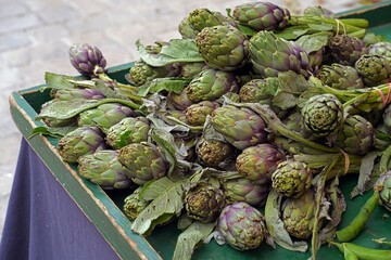 Fresh green and purple artichokes at a farmers market in Provence, France