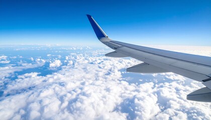 Fototapeta premium Airplane wing above clouds.View from airplane window a blue sky and clouds.