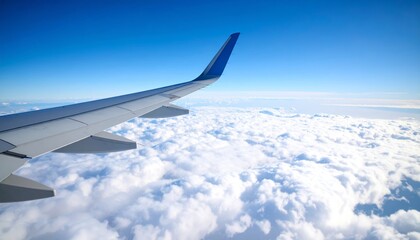 Obraz premium Airplane wing above clouds.View from airplane window a blue sky and clouds.
