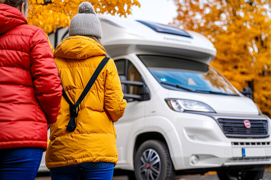 Living and working inside your camper while traveling and a digital nomad-free lifestyle. A woman sitting in an RV enjoys relaxing and connecting to her laptop. The beach in the background outside