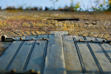 Rustic wooden door viewed from below against a textured brick wall under a clear blue sky