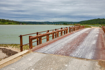 Fototapeta premium Metal bridge extends into calm lake Mirna. Antenal, Croatia.