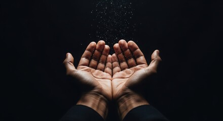 Open hands reaching upward receiving falling glittering particles
