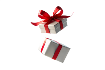 Two white gift boxes with red ribbons and bows are captured in motion one slightly above the other against a clean transparent