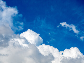 Fluffy clouds in a bright blue sky on a sunny summer day