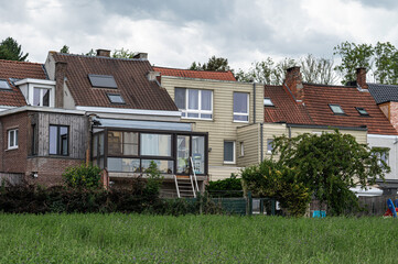 Colorful lawns and agriculture fields with residential houses in the village of Dilbeek, Flemish...