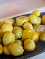 Marinated olives served in a black dish during a Mediterranean dining experience