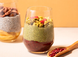 Red Bean Matcha Soya Milk Chia Pudding with Granola and Dried Berries in cup side view of healthy breakfast