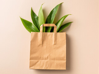 Kraft paper bag with handles and green leaves sticking out of it on beige background