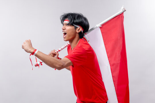 A young man passionately celebrates Indonesia’s Independence Day. His energetic pose and joyful expression convey national pride and excitement.