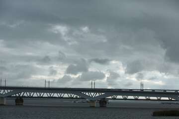 Mysterious clouds hover over a bridge during a gloomy afternoon by the water