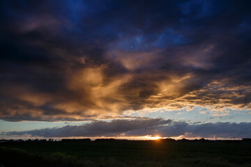 Dramatic sunset over a vast landscape with colorful clouds and distant horizon captured during twilight hours