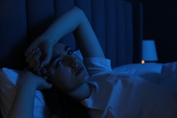 Frustrated woman suffering from insomnia in bed at home