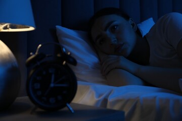Frustrated woman suffering from insomnia in bed at home