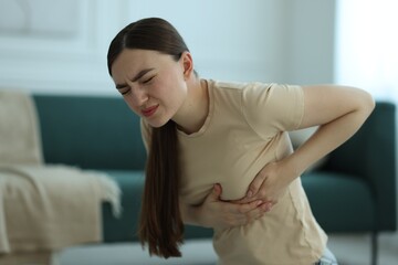 Woman suffering from chest pain at home