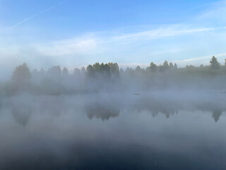 Fog on the shore of the lake at dawn