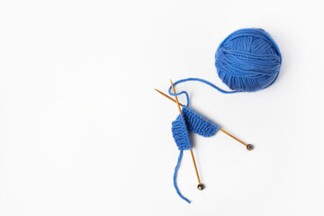 Blue knitted wool on gray background with knitting needles for knitting warm clothes and hobbies...