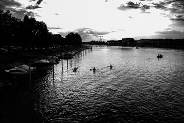 Black and white riverside view with water and trees in the foreground.