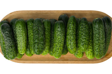Cucumbers in a wooden tray on a white background, top view