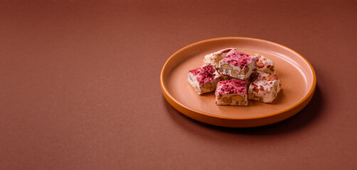 Nougat or white caramel with hazelnuts and strawberry pieces. White nougat