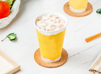 Creamy Iced Milk Tea with Refreshing Boba Style Beverage in a Vibrant Yellow Cup side view of hong...