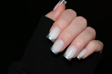 Modern French manicure with silver accents on long nails. Trendy and clean nail art, representing...