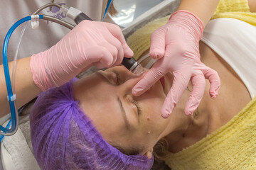 Beautiful woman. Self-care after 40. Beauty industry. Cosmetic treatments. Vacuum facial cleansing. Girl patient. Professional skin care. Prolong youth.