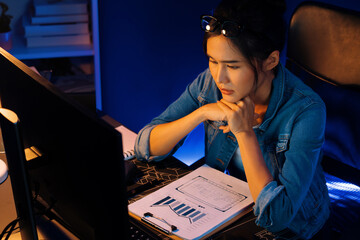 Stressful young beautiful asian creative looking on pc to search project creator social media...
